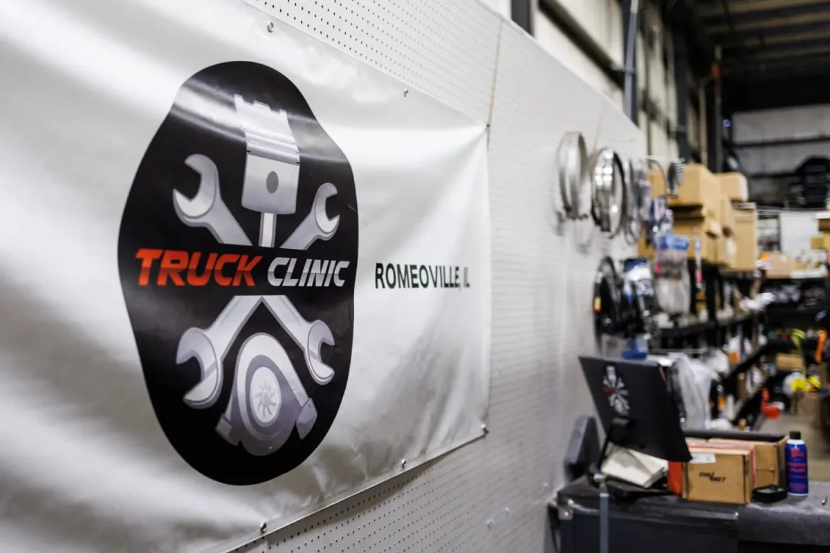 Truck Clinic banner with the Romeoville name displayed inside the workshop
